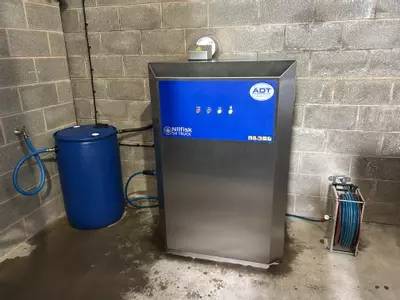 Nilfisk SH Truck stainless static hot pressure washer installed at a Twycross farm for cleaning ATV equipment, with 200L water barrel and boost pump modification.